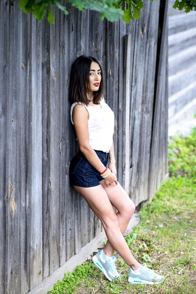 Schönes Mädchen steht am Zaun Stil Mode Frau Sommer im Freien ruht hölzerne — Stockfoto