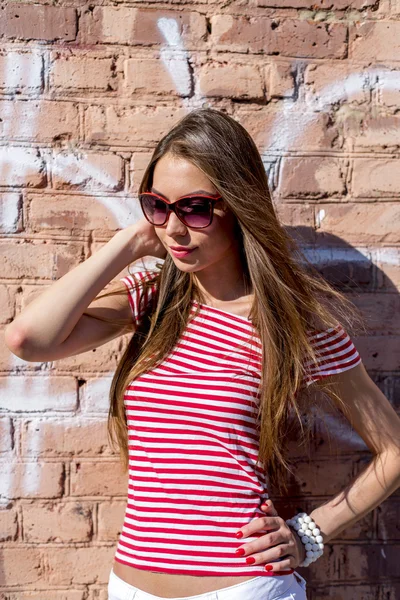 Nahaufnahme Lifestyle Mode Porträt schöne Mädchen lächelnd in der Nähe Ziegelmauer im roten Stil — Stockfoto