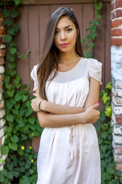 Ayakta sokak, parlak güneşli bir günde, moda stil, kentsel yaşam üzerinde poz, şefkatle bakıyor güzel esmer pembe elbise.