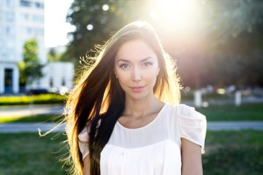 Portre güzel esmer parlak güneş ışığı altında bir park. Kentsel yaşamın moda tarzı, duygusal bakmak