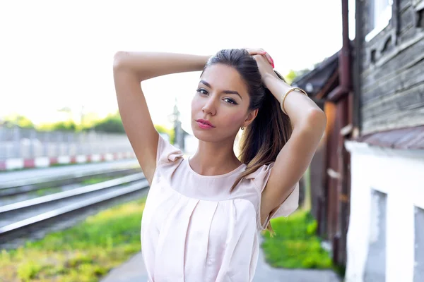 Schönes brünettes rosa Kleid, auf der Straße stehend, ein strahlender sonniger Tag, Modestil, urbanes Leben, posierend, zärtlich schauend. — Stockfoto