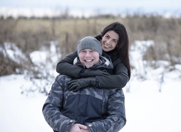 Junges Paar im Freien beim Spielen, Kuscheln im Winterpark. Mädchen umarmt ihren Freund. glücklich entspannende Familien — Stockfoto