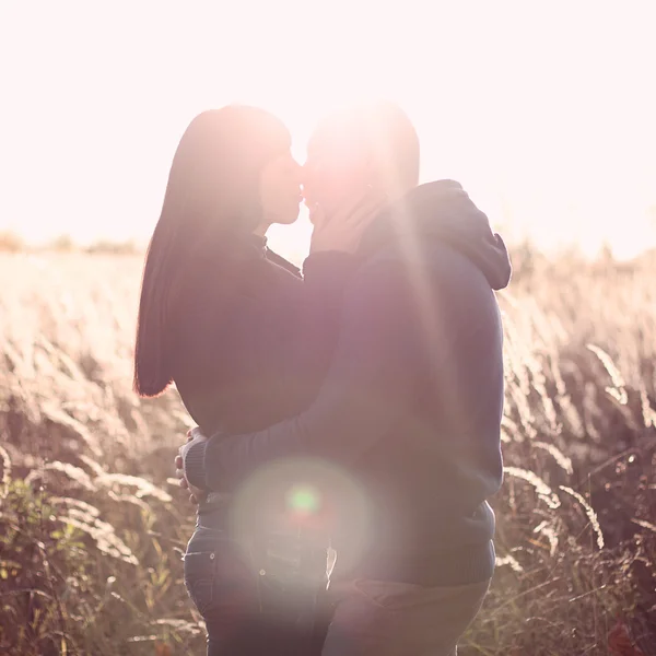Молодая пара целуется в поле — стоковое фото