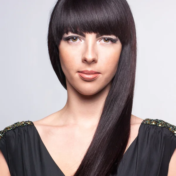 gri bir arka plan üzerinde güzel bir genç kadın