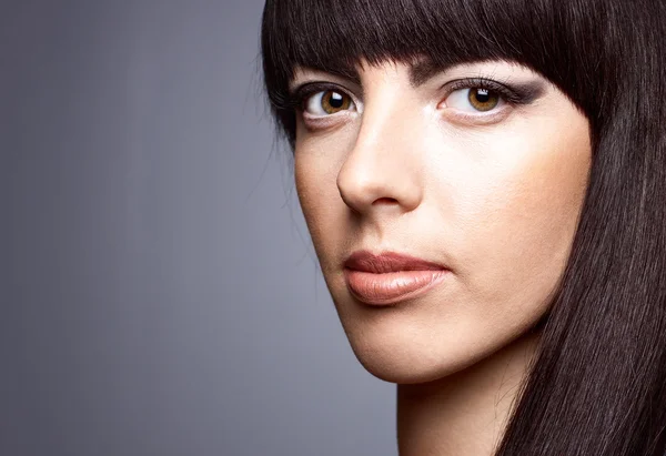 gri bir arka plan üzerinde güzel bir genç kadın