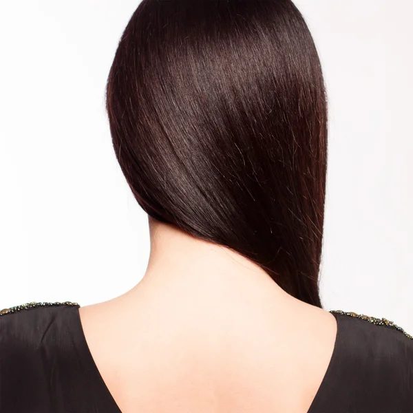Mladá bruneta černé šaty stojí zpět, na bílém pozadí — Stock fotografie