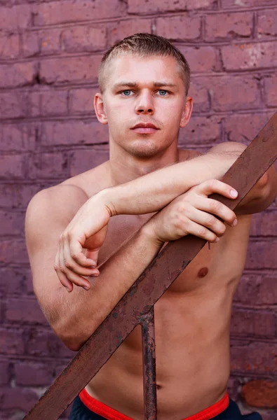 Atleet op een bakstenen muur — Stockfoto