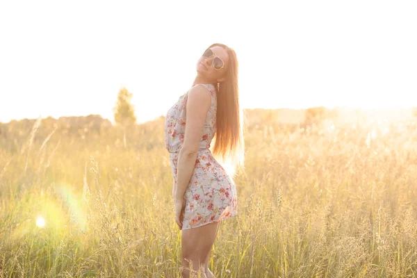 Hermosa chica campo prado verde en el parque de verano delicado vestido, disfrutando del ocio, estilo de moda, la vida de glamour, estudiante en un día soleado brillante . — Foto de Stock