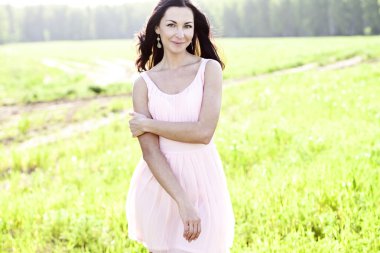 Güzel kadın ayakta bir alan pembe elbise, moda stil, portre açık kavramı