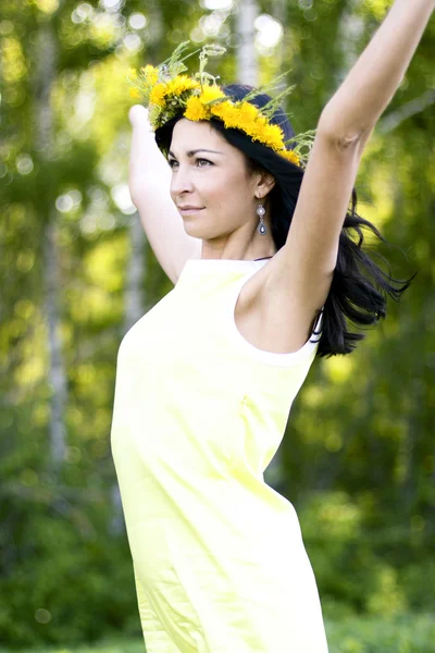 Красивая брюнетка женский стиль на открытом воздухе в желтом платье концепция идея смотреть вдаль с букетом на голове — стоковое фото