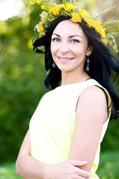 Beautiful brunette woman fashion style outdoors in yellow dress smiling happy concept idea bouquet on her head — Stock Photo, Image