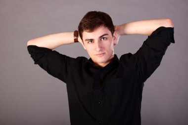 Genç işadamı bir siyah gömlek, moda stil, gençlik yön, kavram fikir iş adam gri arka plan, profesyonel görünüm adam