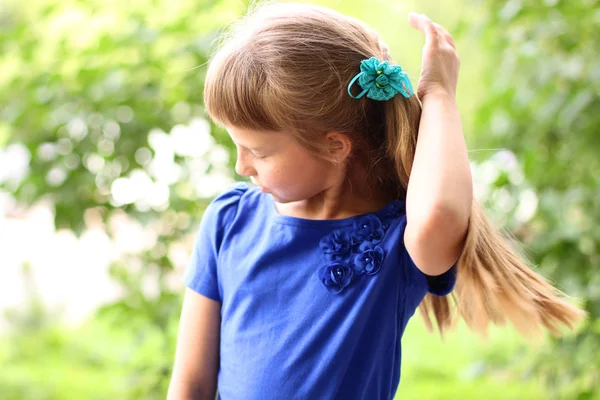 Kleines Mädchen blaues Kleid hell sonnigen Sommertag Park zwischen grünen Büschen, suchen Idee Konzept der Teen-Mode-Stil, posiert für Porträt — Stockfoto