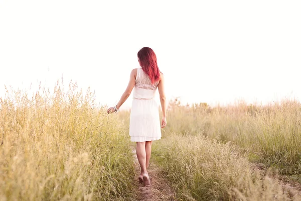 A menina de figura esbelta que corre tarde de verão quente, em um vestido, felicidade de conceito, prazer, nascer do sol e pôr-do-sol, um prado de primavera — Fotografia de Stock