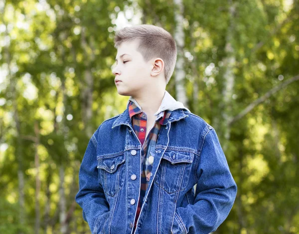 Menino confiante em pé campo, parque, descansando desfrutando de camisa jaqueta de jeans ar feliz — Fotografia de Stock