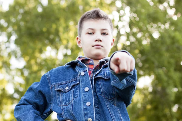 Jistý mladík stojící pole, park, odpočívá se těší happy vzduchu jeansové bundy košile ukazuje palec, idea silného muže koncept vtip důvěry — Stock fotografie