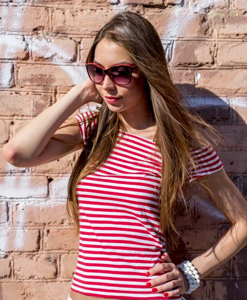 Nahaufnahme Lifestyle Mode Porträt schöne Mädchen lächelnd in der Nähe Ziegelmauer im roten Stil — Stockfoto