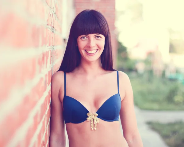 Girl in swimsuit at the brick wall sunning lifestyle summer — Stock Photo, Image