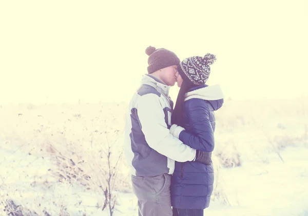 Pareja joven besándose en la naturaleza en invierno — Foto de Stock