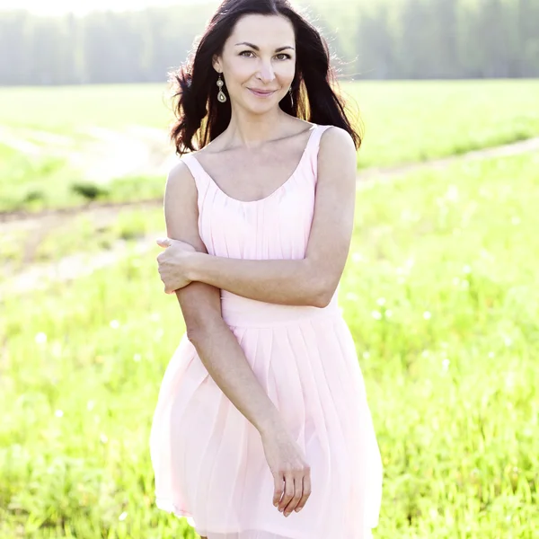 Krásná žena, která stála v oblasti růžové šaty, módní styl, pojetí portrétu venkovní — Stock fotografie