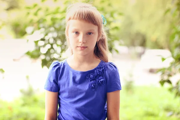 Kleines Mädchen blaues Kleid hell sonnigen Sommertag Park zwischen grünen Büschen, suchen Idee Konzept der Teen-Mode-Stil, posiert für Porträt — Stockfoto