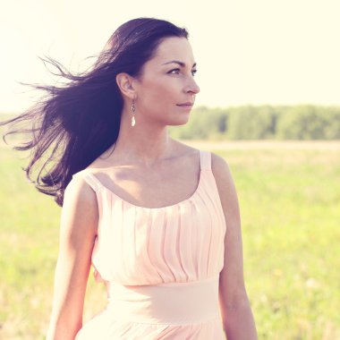 Güzel kadın ayakta bir alan pembe elbise, moda stil, portre açık kavramı