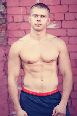 Bir tuğla duvar, vücut geliştirmeci