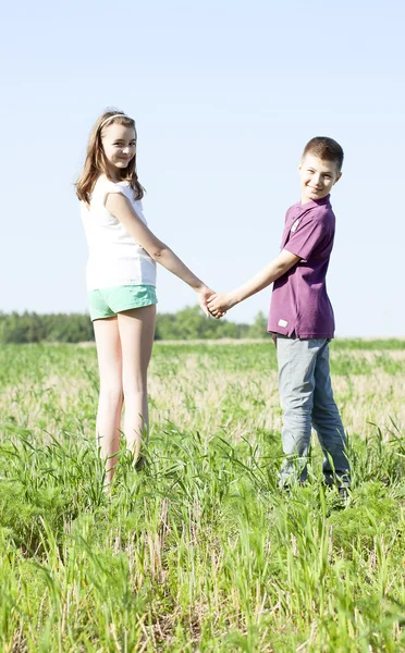 Summer sunny day park stands boy with girl holding hands enjoy nature, Meadow, fun small family relationships, idea concept happiness lifestyle — стоковое фото