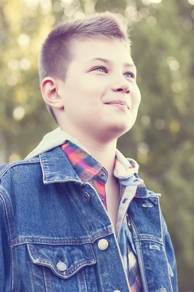 年轻的男孩站在公园草地上阳光灿烂的日子，牛仔裤夹克、 衬衫遥望远方 — 图库照片