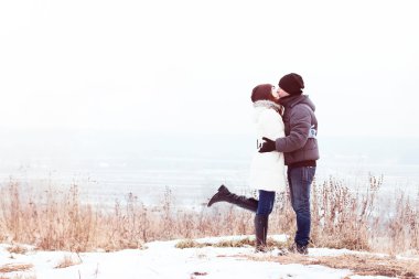 Birbirimizi, mutlu bir aile, fikir tarzı kavramı ilişkiler, kıyafet şapka genç çift Kış park, orman, öpüşme, aşk