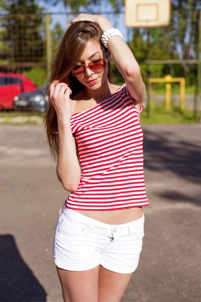 Schöne junge Frau, im Freien, ruht leuchtend rotes T-Shirt, Mode-Stil, glücklich brünette Haarglättung — Stockfoto
