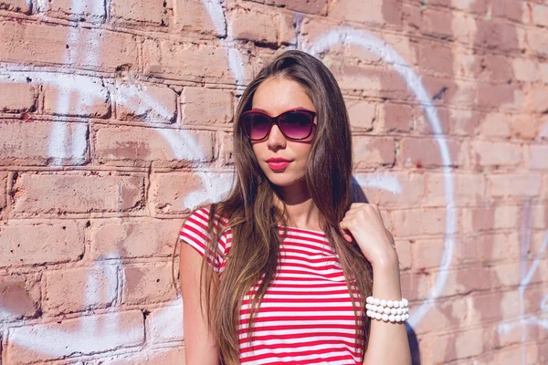 Όμορφη νεαρή γυναίκα, σε εξωτερικούς χώρους, αναπαύεται σε ένα φωτεινό κόκκινο μπλουζάκι, στυλ μόδας — Φωτογραφία Αρχείου