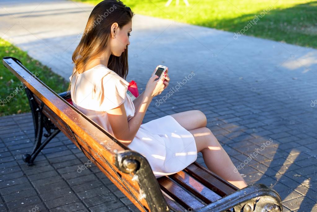 美しいブルネットの女の子は ドレスでベンチに座ってメッセージ電話パークを書き 仕事の後にリラックスした夏の日のビジネスウーマン ソーシャルネットワークでの都市生活はニュースフィードを読みます ストック写真 C Byswat 美しいブルネットの女の子は ドレスでベンチに座ってメッセージ電話パークを書き 仕事の後にリラックスした夏の日のビジネスウーマン ソーシャルネットワークでの都市生活はニュースフィードを読みます ストック写真 C Byswat