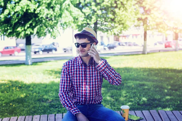 Mann in Hemd und Jeansbrille, telefonierend, Smartphone, Sommerkonzept, Geschäftsmann-Urlaub. Lebensstil in der Stadt. die Straße im Park. — Stockfoto
