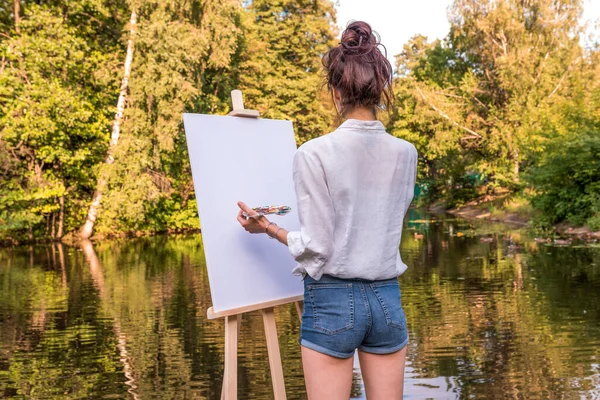Gadis seniman melihat dari belakang, wanita menggambar, taman musim panas danau sungai, menciptakan kreativitas artistik suasana hati. Kanvas putih kosong, memulai. Latar belakang pohon air. — Stok Foto