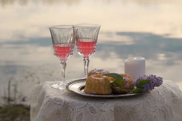 Twee glas roze wijn, kaars en Lila op tafel buiten — Stockfoto