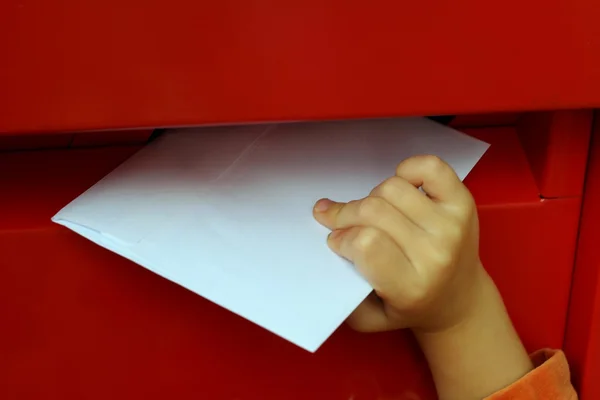 Children's hand putting letters in mailbox — Stock Photo, Image