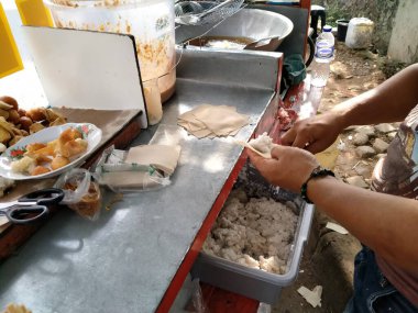 Jakarta, Endonezya - 27 Mayıs 2020: Hamuru işleyen bir adamın eli (Batagor Bandung) tofu ve hamur köftesi derisine doldurulmuş uskumru balık köftesi hamurundan oluşur.