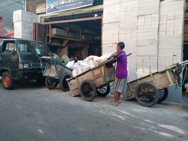 Tambora, Batı Jakarta, Endonezya - 1 Ekim 2020: Kum torbaları taşıyan inşaat işçisi