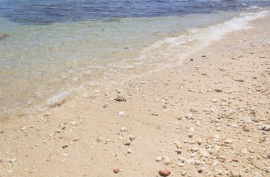 Kumsalda küçük dalgalar, berrak suyla