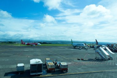 Bandar udara Ngurah Rai, Bali, Endonezya - 4 Aralık 2018: Havaalanından kalkacak uçak. Birçok kargo vagonu uçağa mal taşıyacak.