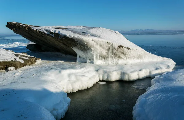 Rochers gelés dans la mer par une journée ensoleillée d'hiver. — Photo