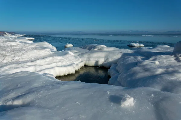 Rochers gelés dans la mer par une journée ensoleillée d'hiver. Photos De Stock Libres De Droits