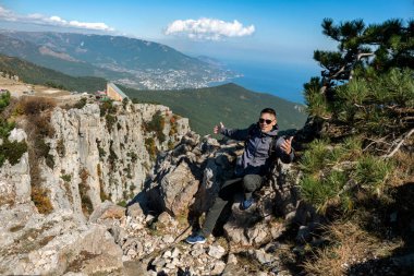 Güneşli bir yaz gününde genç bir adam Ai-Petri Dağı 'nın zirvesinde. Turizm konsepti, aşırı .