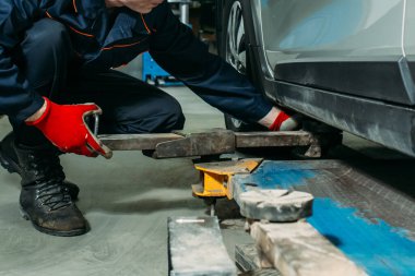 Garajdaki lastik montajı, işçi tekerleği çıkarır, lastiği ayarlar ve tekerleği yerleştirir.