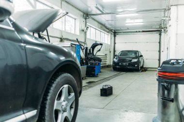 Otomobil atölyesinde kaputu açık bir servis arabası var.
