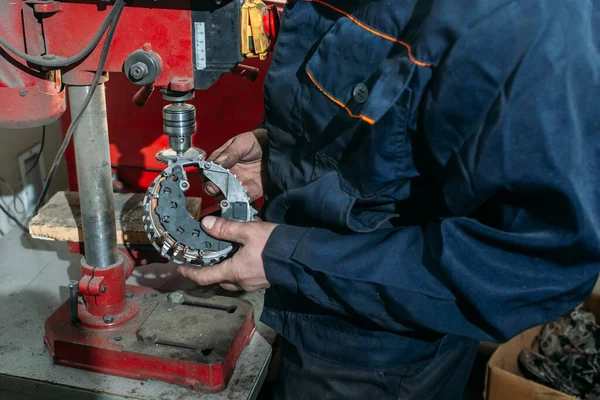 a worker in a car repair shop tests and repairs a generator