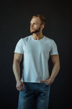 Güçlü bünyesi olan genç bir adam güzel gövdeli bir vücut geliştirici figürüne sahip. Stüdyoda siyah bir arkaplanda çekim yapmak..