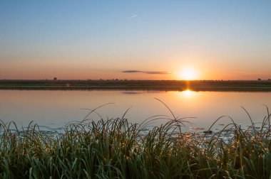 Rusya 'nın Bashkortostan cumhuriyetinde, Agidel' de küçük bir nehirde güzel bir gün batımının tadını çıkarıyorum.