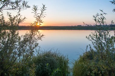 Rusya 'nın Bashkortostan cumhuriyetinde, Agidel' de küçük bir nehirde güzel bir gün batımının tadını çıkarıyorum.